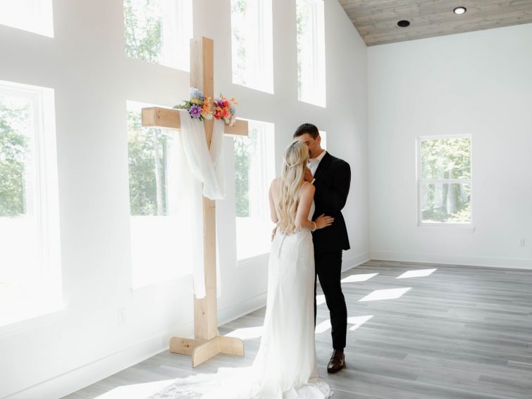 IMG_5961 bride and groom kissing in front of cross altar